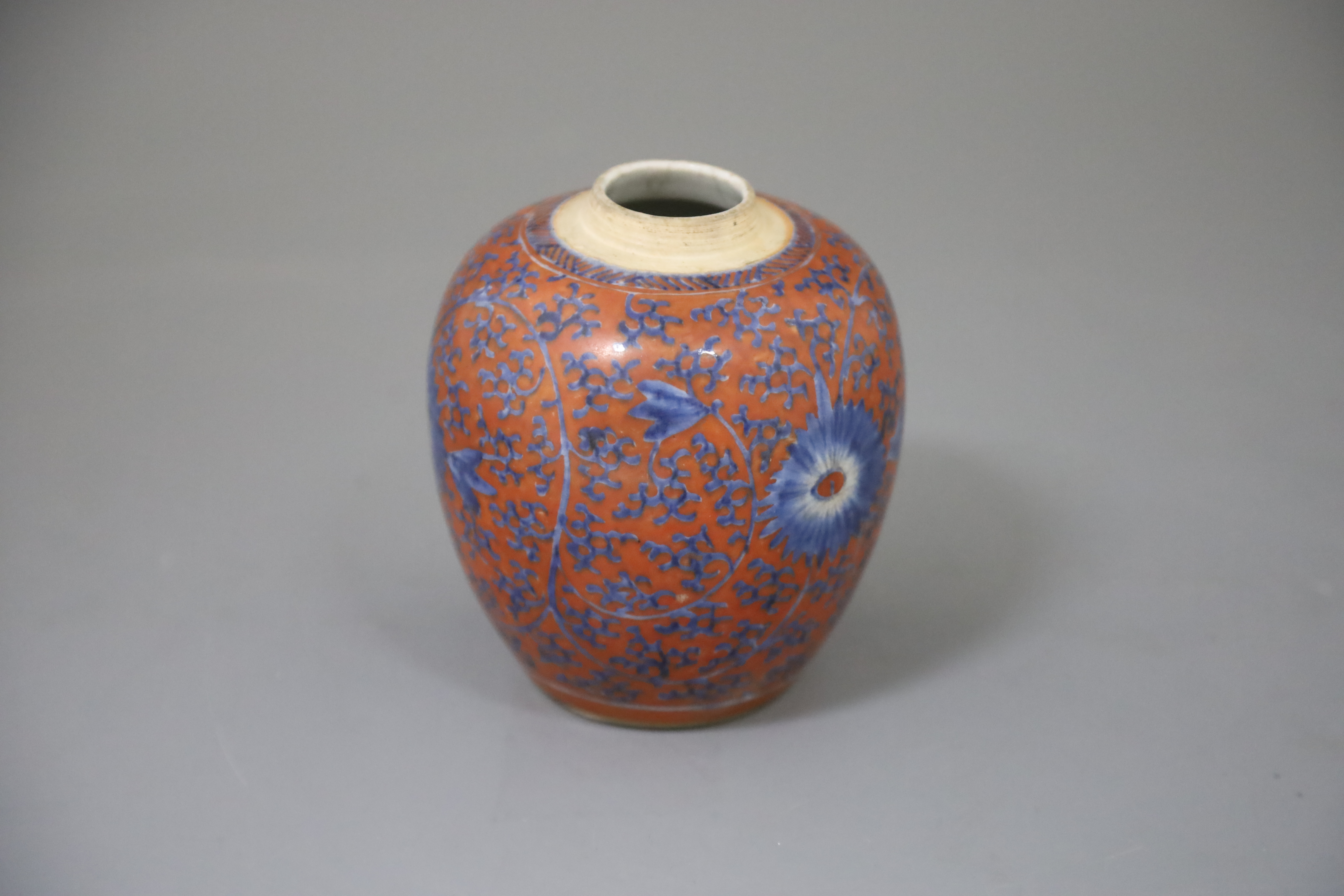 A Chinese coral red ground underglaze blue jar, Kangxi period, H. 12.3cm, excluding wood cover and stand